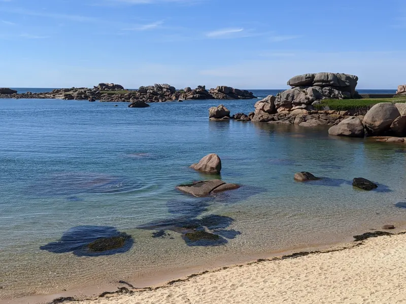 Une plage de sable entre les rochers de granit rose